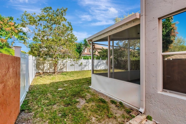 view of yard featuring a sunroom and a fenced backyard