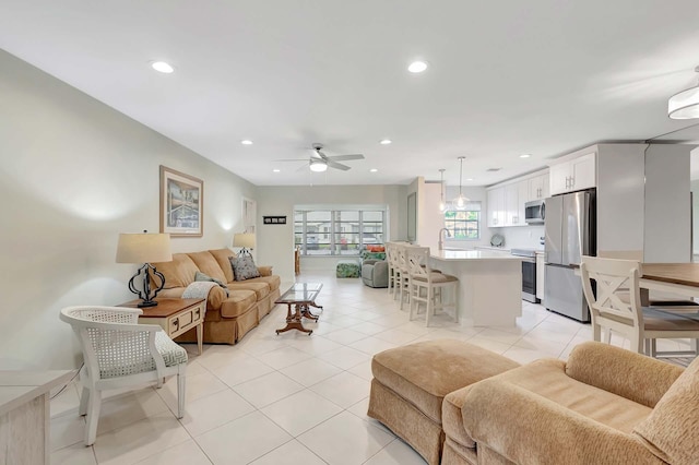 living area featuring light tile patterned flooring, a ceiling fan, and recessed lighting