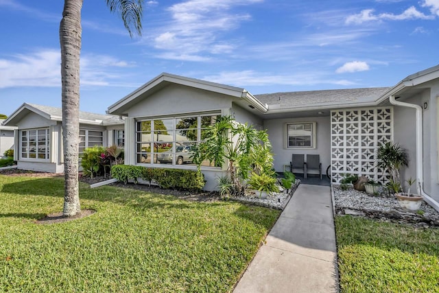 single story home featuring a front yard and stucco siding