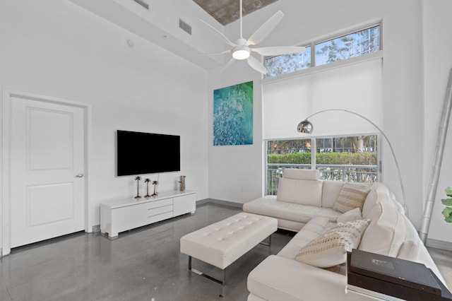 living room with baseboards, visible vents, a ceiling fan, finished concrete floors, and a high ceiling