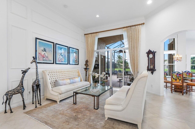 living area with ornamental molding, arched walkways, light tile patterned flooring, and an inviting chandelier