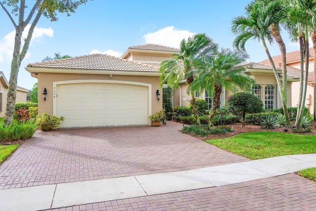 view of front of home with a tiled roof, decorative driveway, an attached garage, and stucco siding