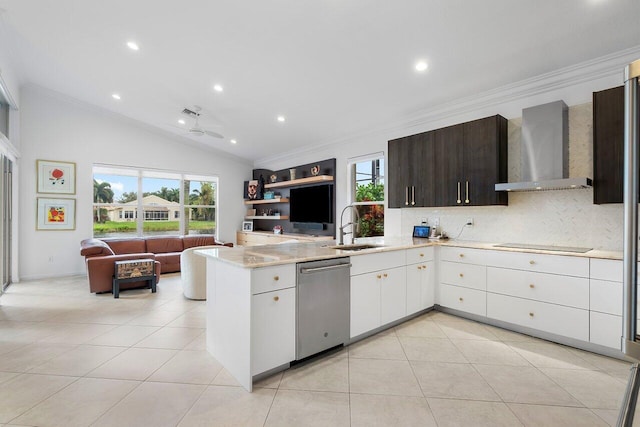 kitchen with stainless steel dishwasher, open floor plan, a sink, wall chimney range hood, and a peninsula