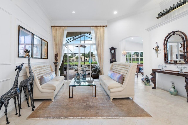 living area with light tile patterned floors, recessed lighting, arched walkways, and ornamental molding