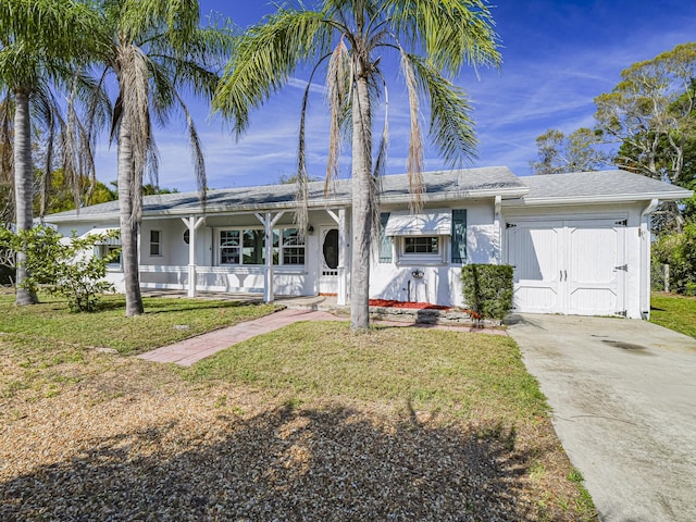 view of front of house featuring a garage, driveway, a front lawn, and stucco siding