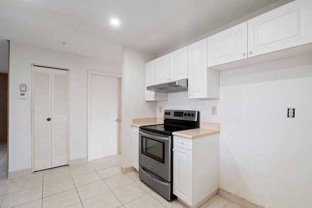 kitchen with electric stove, light tile patterned floors, light countertops, white cabinets, and under cabinet range hood