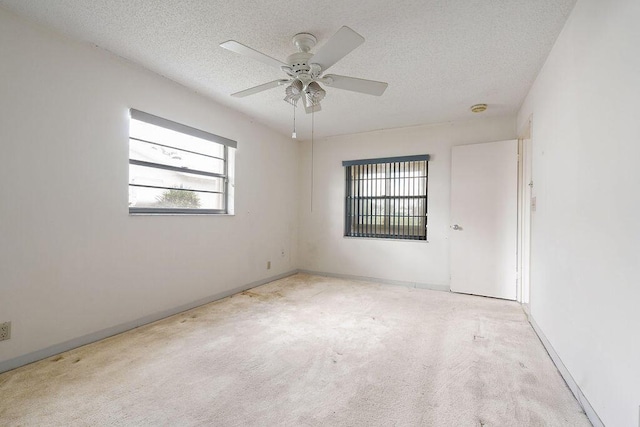 unfurnished room featuring a ceiling fan, carpet flooring, a textured ceiling, and baseboards