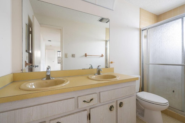 bathroom with a sink, toilet, and a shower stall