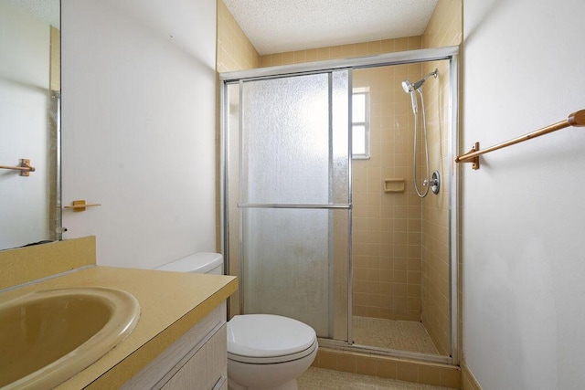 bathroom featuring toilet, a shower stall, a textured ceiling, and vanity