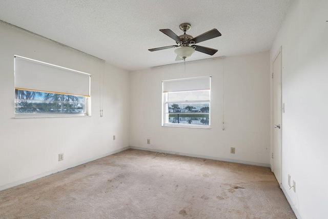 spare room with a ceiling fan, carpet flooring, and a textured ceiling