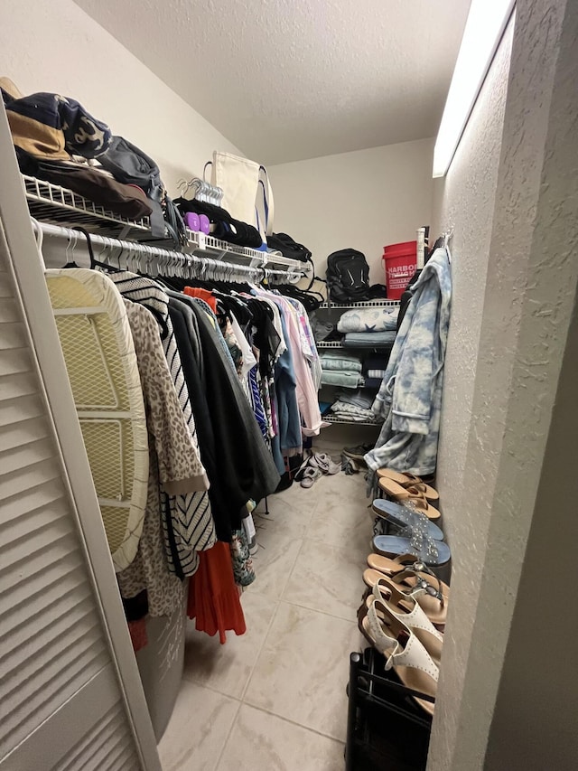 spacious closet with light tile patterned floors