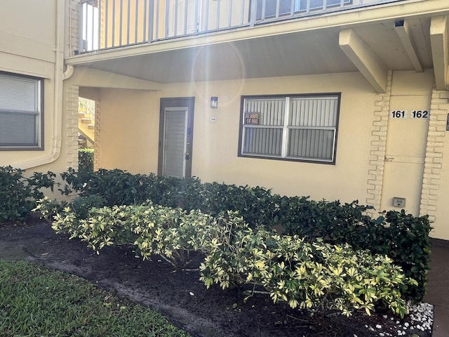 entrance to property featuring stucco siding