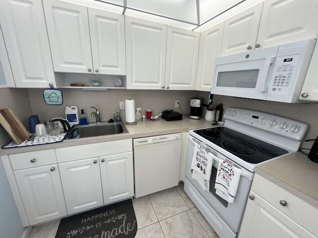 kitchen with light countertops, white appliances, a sink, and white cabinetry