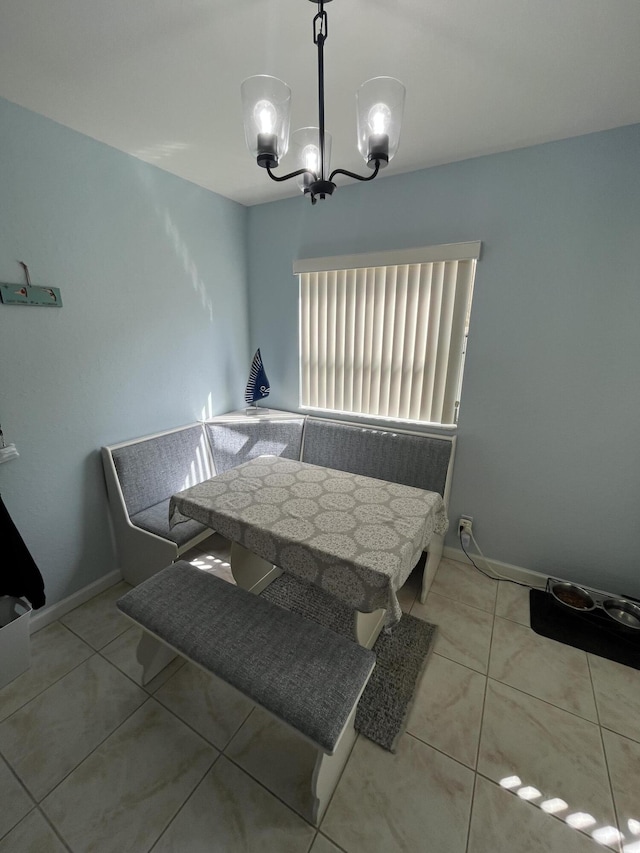 dining space featuring baseboards, breakfast area, a notable chandelier, and light tile patterned flooring