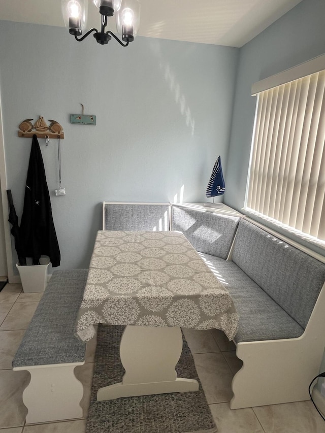 dining space featuring light tile patterned floors and a notable chandelier