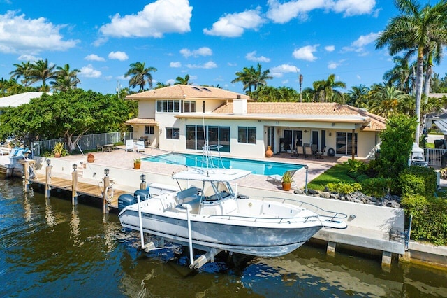 rear view of property with a water view, fence, a fenced in pool, and a patio