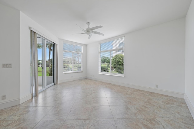 empty room with ceiling fan, baseboards, and light tile patterned flooring