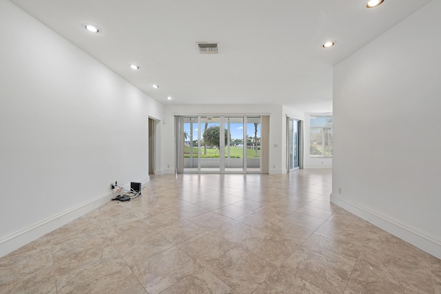 empty room featuring baseboards, visible vents, and recessed lighting