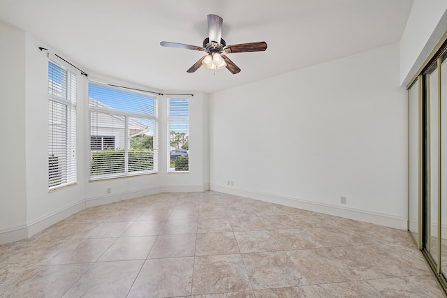 spare room with baseboards, a ceiling fan, and light tile patterned flooring