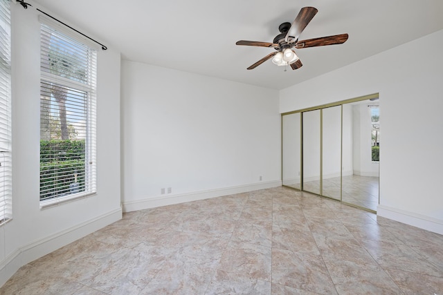 unfurnished bedroom featuring a ceiling fan, a closet, and baseboards