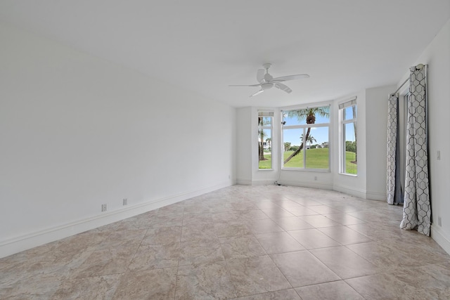 spare room featuring ceiling fan and baseboards