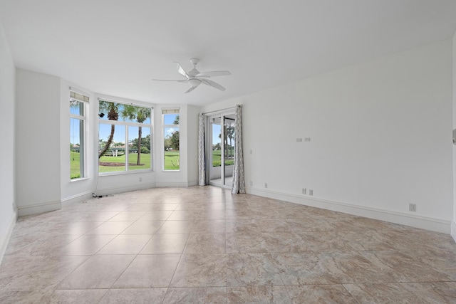 empty room featuring ceiling fan and baseboards