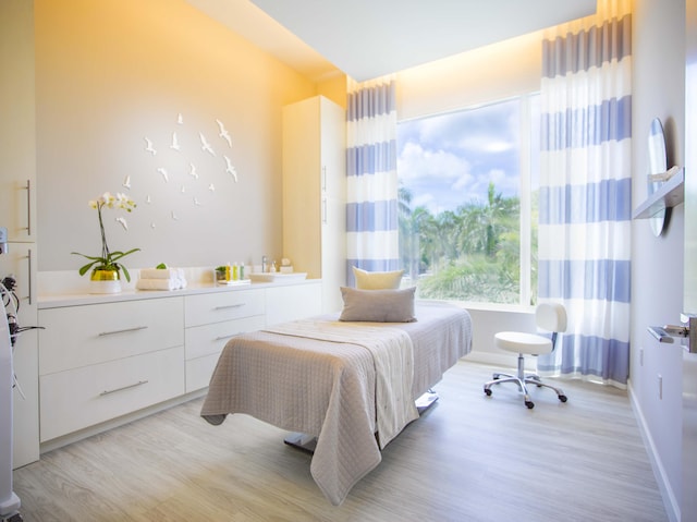 bedroom with light wood-style flooring and baseboards