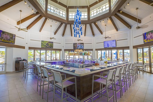 interior space featuring high vaulted ceiling, beam ceiling, and light tile patterned floors