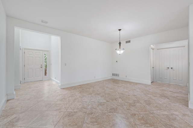 spare room featuring baseboards and visible vents