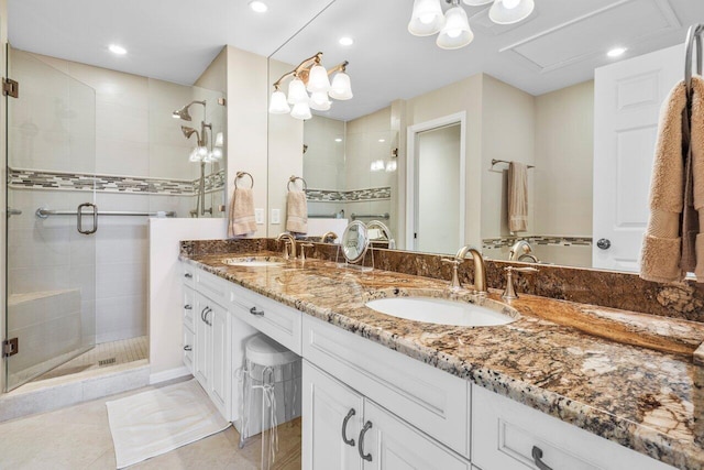 full bathroom featuring double vanity, a stall shower, tile patterned flooring, and a sink