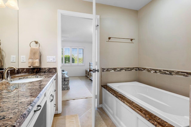 ensuite bathroom with connected bathroom, vanity, a bath, and tile patterned floors