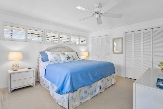 carpeted bedroom with multiple closets, crown molding, and ceiling fan