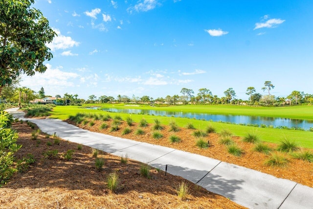 surrounding community featuring a water view and a lawn