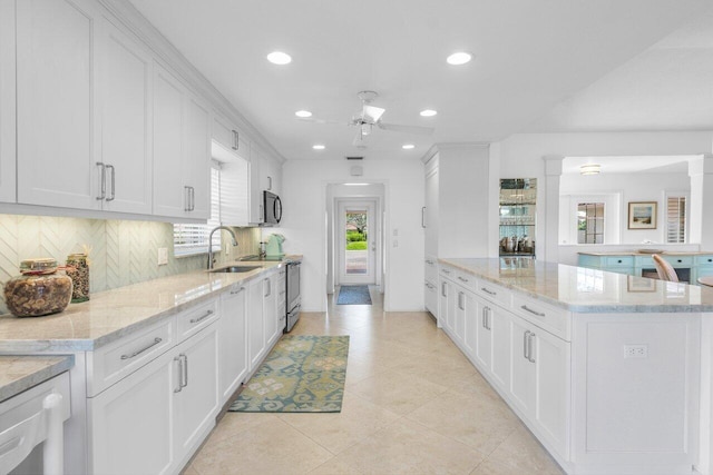 kitchen with tasteful backsplash, black microwave, white cabinetry, and stainless steel electric range oven