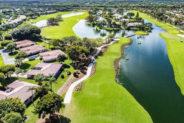 drone / aerial view featuring golf course view, a water view, and a residential view