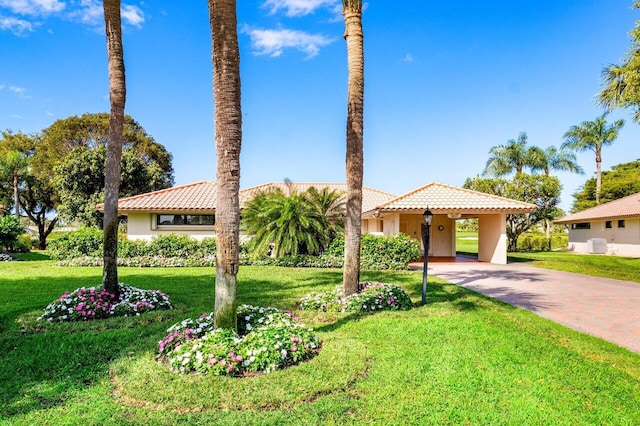 view of front of house with central AC unit, stucco siding, a tile roof, decorative driveway, and a front yard