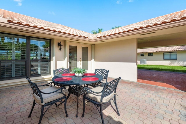 view of patio / terrace featuring outdoor dining space, french doors, and central AC