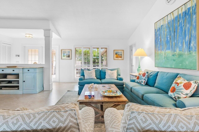 living room with light tile patterned floors and decorative columns