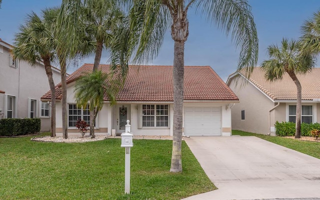 view of front facade with an attached garage, concrete driveway, a tiled roof, stucco siding, and a front yard