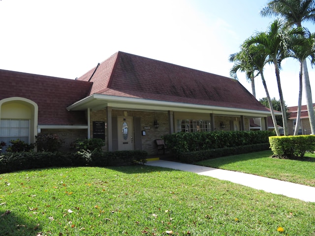 5580 Tamberlane Cir Unit 334, Palm Beach Gardens, FL 33418 - view of front of house featuring a front lawn, roof with shingles, and brick siding