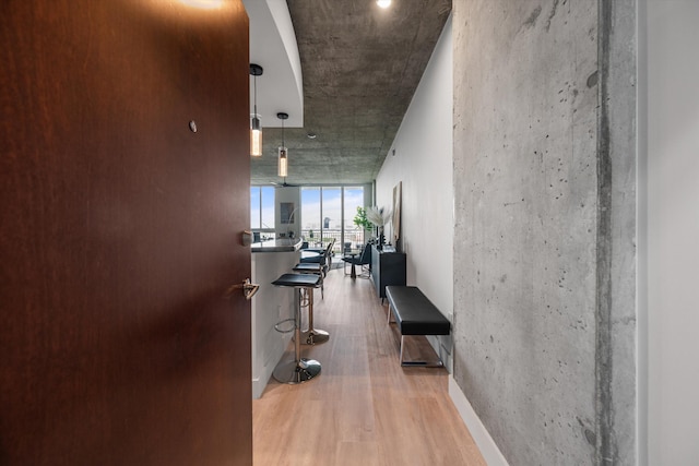 corridor featuring a wall of windows and wood finished floors