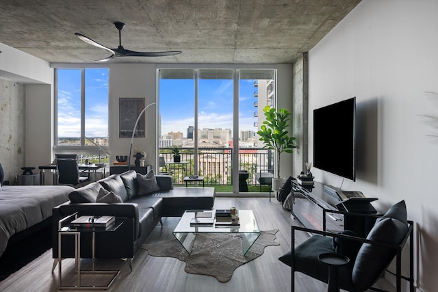 living area featuring ceiling fan, floor to ceiling windows, a wealth of natural light, and wood finished floors