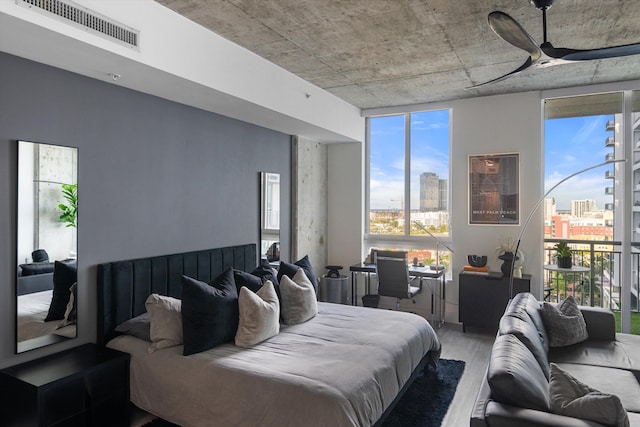 bedroom featuring visible vents, a city view, and wood finished floors