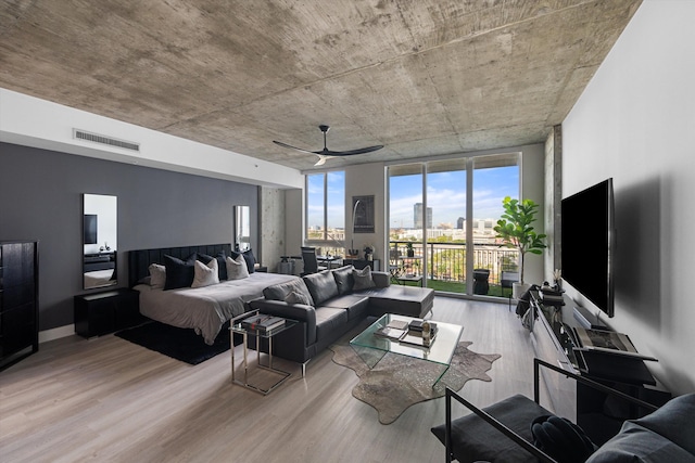 bedroom with access to exterior, floor to ceiling windows, visible vents, and wood finished floors