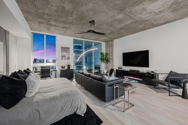 bedroom featuring ceiling fan, expansive windows, and wood finished floors