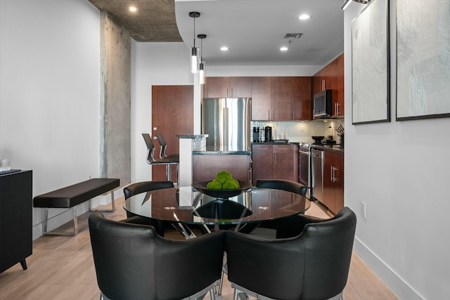 dining space with light wood-style flooring, visible vents, baseboards, and recessed lighting