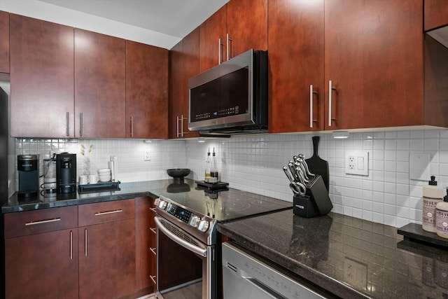 kitchen with appliances with stainless steel finishes, dark stone countertops, and tasteful backsplash