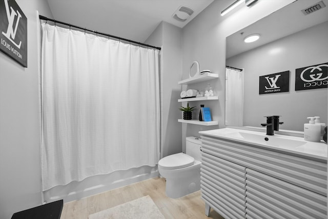 bathroom featuring visible vents, vanity, toilet, and wood finished floors