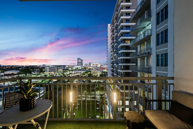 balcony at dusk featuring a city view