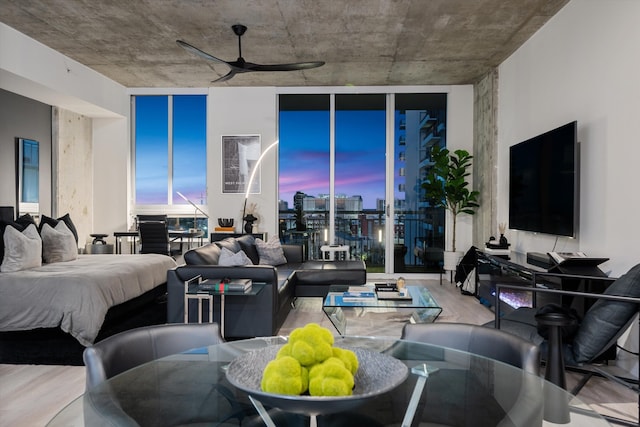 living area featuring wood finished floors, a ceiling fan, and floor to ceiling windows